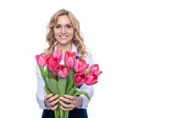 cheerful young woman in apron with spring tulip flowers isolated on white background.
