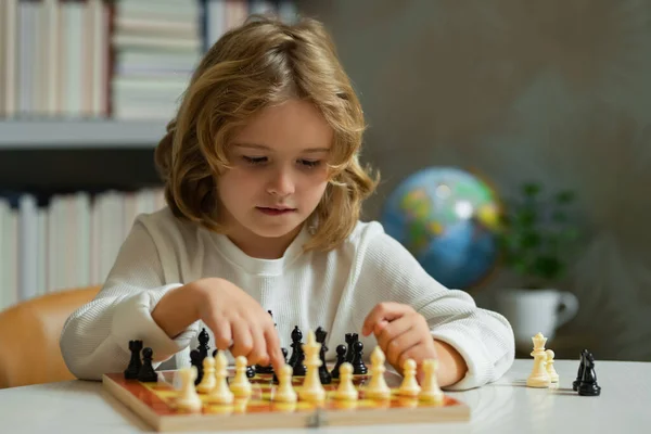 Chess school. Concentrated child play chess. Kid playing board game in classroom