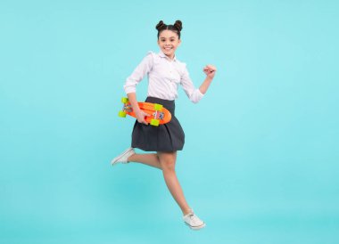 Teen hipster girl skater with skateboard on isolated background. Jump and run. Summer kids trend, urban teenage style