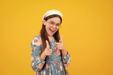 Mutlu ergen, pozitif ve gülümseyen duygular. Sarı arka planda yalnız poz veren neşeli genç çocuk seni işaret ediyor.