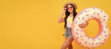 Yaz çocuğu. Güneş yanığı. Yaz tatili. Hasır şapkalı mutlu kız ve güneş gözlüğü şişirilebilir çörek halkası. Yazlık mayo giyen kız çocuğu afişi, fotokopi alanı olan poster başlığı