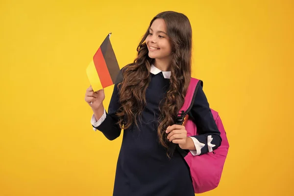 Portrait of school girl with backpack hold germany flag. Education and learning in Germany, Deutschland, deutsche flag. Teen student study in Germany. Language learning