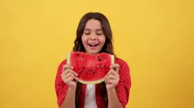 amazed child going to eat water melon slice on yellow background, yummy.