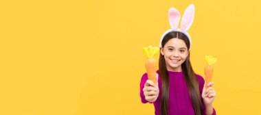 surprised teen kid in easter bunny ears with carrot, bunny hunt. Easter child horizontal poster. Web banner header of bunny kid, copy space