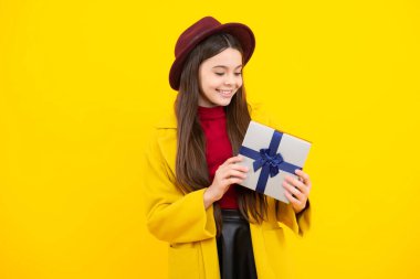 Mutlu ergen portresi. Stüdyonun arka planında hediye kutusu olan çocuk. Çocukların doğum günü hediyesi. Gülümseyen kız