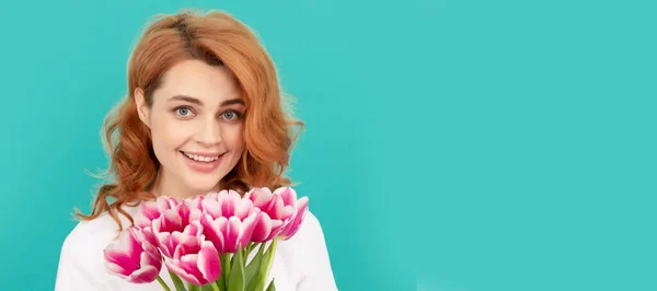 happy woman with tulip flower bouquet on blue background. march 8. Woman isolated face portrait, banner with mock up copyspace