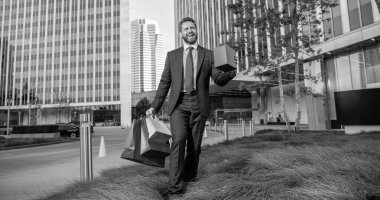 Girişimci doğum günü hediyesi taşır. Adam alışveriş torbalarını tutuyor. Erkekler günü. Paketleri olan mutlu bir iş adamı. Satış ve indirim. Ona sürpriz yapacağım. Sevgilim olur musun? Boks günü. Kutusu olan neşeli adam..