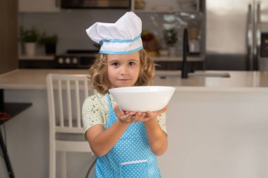 Aşçı aşçı çocuk mutfakta yemek hazırlıyor. Çocuk lezzetli yapıyor. Yemek pişirme