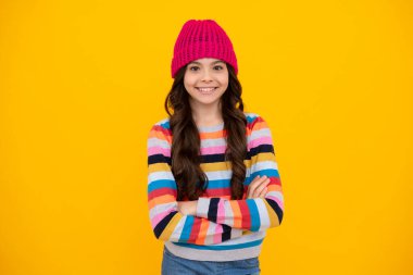 Fashion happy young woman in knitted hat and sweater having fun over colorful blue background. Happy teenager, positive and smiling emotions of teen girl