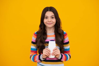 Genç kız şişe şampuanı ya da duş jeli gösteriyor. Saç kozmetik ürünü. Reklam için şişe fotokopi alanı oluşturun. Mutlu ergen, pozitif ve gülümseyen genç kız duyguları