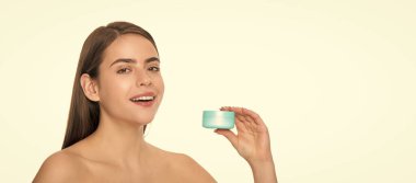 Temizleme fırçası. kopyalama alanı. Bayan kozmetik ürünü sunuyorum. Kadın yüz kremi kullanıyor. Gülümseyen kız saç maskesi tutuyor. Cilt kremi olan bayan. Günlük alışkanlık ve kişisel bakım. Cilt güzelliği.