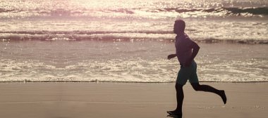 Adam koşuyor ve zıplıyor, afişi kopyalanmış. Hızlı siluet. Dayanıklılık ve dayanıklılık. Sporcu okyanusta kazanmak için hızlı koşar.