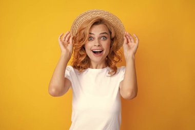 Şaşırmış yüzlü, etkileyici bir kız. Hasır şapka takan gülümseyen beyaz kadın yazın tadını çıkarıyor.