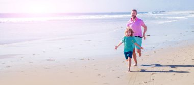 Baba ve oğul yaz plajında açık havada koşuyor. Kopya alanı olan afişler, yaz plajında koşan baba ve oğul. Aile seyahati ve tatil