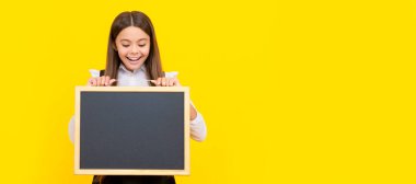 Şaşırmış çocuk yenilik bilgisi sunuyor. Çocukluk eğitimi. Liseli kız öğrenci pankartı. Kopya alanı olan öğrenci portresi