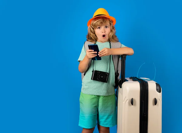 Kids travel. Happy child boy in travel hat with suitcases isolated on studio backgraund. Travel lifestyle and dreams of travel