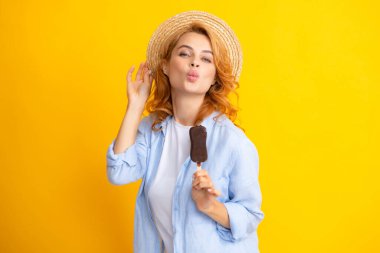 Sarı izole edilmiş arka planda çikolatalı dondurmayla poz veren kız. Yaz kadını