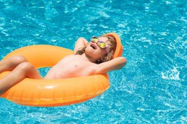 Çocuk havuzda yüzüyor ve oynuyor. Çocuk yüzme havuzunda oynuyor. Yaz tatili kavramı. Yaz çocukları portresi