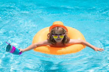 Mutlu çocuk, yaz tatilini dışarıda, yüzme havuzunda, suyun içinde keyifle geçiriyor.