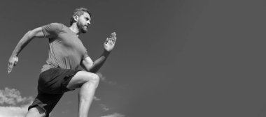 Koşan ve zıplayan adam, fotokopi alanı olan pankart. Sporcu sporcu kazanmak için hızlı koşar. Erkek egzersiz aktivitesi. fitness takımı giyen adam spor giyer.