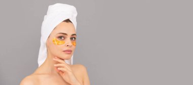 beautiful girl with terry towel use facial golden eye patch for skin, healthy skin. Beautiful woman isolated face portrait, banner with mock up copy space