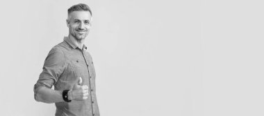 İnsan yüzü portresi, fotokopi alanı olan pankart. Saçları ağarmış gülümseyen olgun bir adam sarı arka planda baş parmağını gösteriyor, kopyalama alanı, başarı