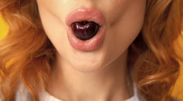 Womans enjoying fresh sweet cherry. Female mouth eating sweet cherry. Closeup female mouth tasting sweet cherry