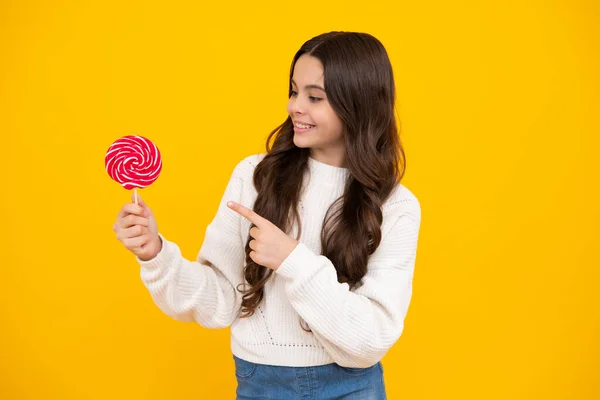 Excited face. Teenage girl with candy lollipop, happy child 12, 13, 14 years old eating big sugar lollipop, sweets candy. Happy face, positive and smiling emotions of teenager girl