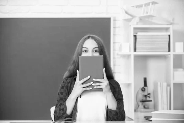 back to school. teen girl ready to study. kid do homework with book. teenager student. modern education. high school. schoolgirl with copybook. child hiding behind notebook.