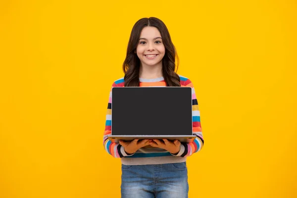 School student using laptop. E-learning and online education. Teen girl on internet video chat isolated on isoalted yellow background. Screen of laptop computer with copy space mockup