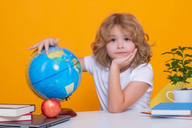 Back to school. Portrait of cute child school boy, isolated on yellow studio background. School and education kids concept. Clever kid with school supplies