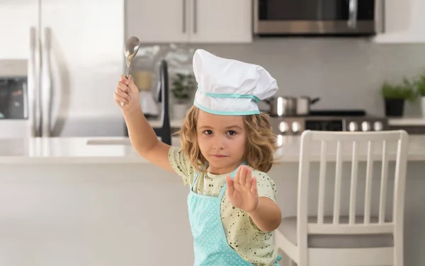Kid chef cook cookery at kitchen. Portrait of little child in uniform of cook. Cute child to be a chef. Child in chef hat