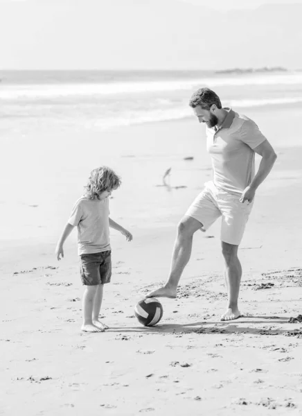 daddy with kid boy on summer day. weekend family day. dad and child having fun outdoor. childhood and parenting. family holidays. sport activity. father and son play football on beach.
