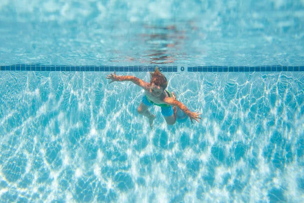 Kid boy swim underwater in sea. Kid swimming in pool under water. Active kid swimming, playing and diving, children water sport