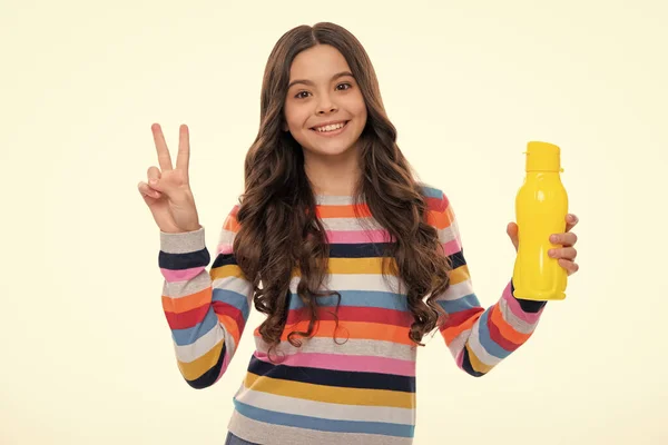 Teen holds water bottle isoalted on white. Child girl care body hydration. Active leisure and water balance. Active and healthy kid drink water. Happy girl face, positive and smiling emotions