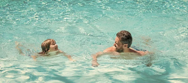 Baba ve oğul yüzme havuzunda, fotokopi alanı olan pankart. Aile gününde yaz tatili tatili. baba ve çocuk havuz partisinde eğleniyorlar.