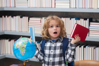 Okul öğrencisi sınıfta öğreniyor, okulda İngilizce öğreniyor. İlkokul çocuğu. Komik bir öğrencinin portresi.