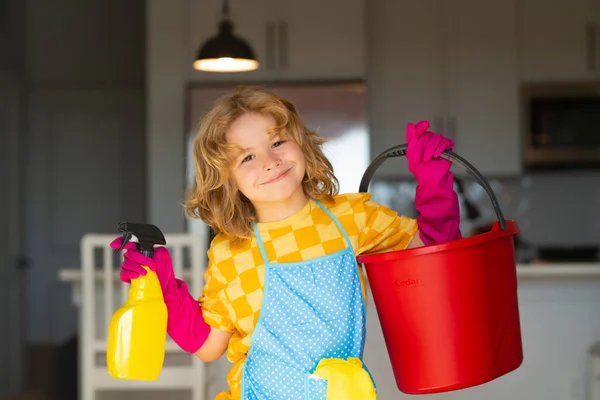 Little kid cleaning at home. Child doing housework having fun. Portrait of child housekeeper with wet flat mop on kitchen interior background