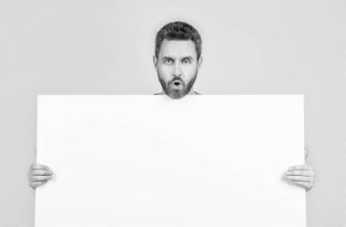 Yararlı bilgi için yer. kopyalama alanı. Terfi ve yaratıcılık için bir yer. Pazarlama tasarımın için. Kağıt pankartıyla şok olmuş sakallı adam. Şaşırmış adam duyuru yapıyor. Erkek kağıt çarşaf arkasında.