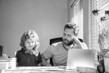 Okula dönüyorum. konsantre baba ve oğul evde bilgisayar kullanıyor. Aile ve ebeveynlik blogu. Çocuk özel öğretmeniyle ödev yapıyor. Webinar video dersi. Bilgisayarda online eğitim. evde eğitim.