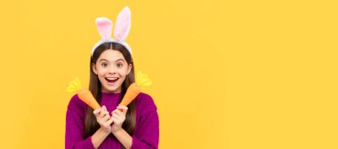 happy easter holiday. funny child in hare ears hold carrot. teenager girl wear rabbit costume. Easter child horizontal poster. Web banner header of bunny kid, copy space