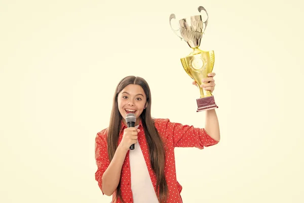 Teenage girl with win cup microphone speech. Teen holding a trophy. Kid winner child won the competition, celebrating success and victory