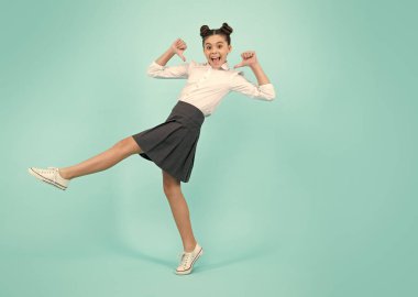 Amazed teenager. Happiness, freedom, motion and child. Young teenager girl wear summer dress jumping in air over blue background. Excited teen girl