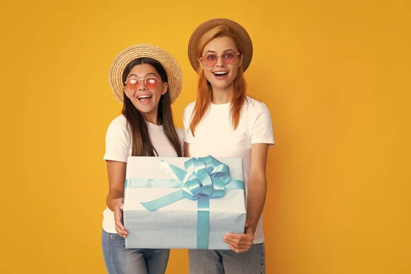Mothers day. Family, child, holiday and party concept. Smiling mother and daughter with gift box. Cheerful mom and her cute daughter girl with gifts. Parent and child having fun