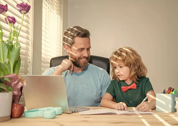webinar video lesson. online education on laptop. homeschooling and estudy. back to school. busy father and son use communication technology at home. family blog. boy do homework with teacher.