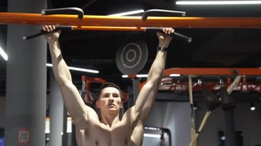 pullup. muscular athlete practicing pullup in sport gym. athlete do pullup workout. athlete pull up in sport gym.