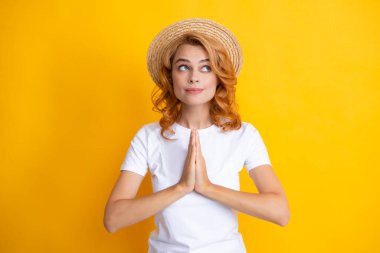 Hasır şapkalı genç kızıl saçlı kadın, şaşırmış yüz ifadesi, sarı arka planda soyutlanmış. Yaz yaşam tarzı stüdyo resmi