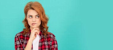 thinking redhead woman with curly hair in checkered casual shirt, decision. Woman isolated face portrait, banner with mock up copyspace