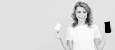 happy woman showing credit or debit card and smartphone to make online shopping, online banking. Woman isolated face portrait, banner with mock up copy space