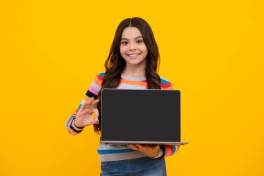 Young student school girl, studying with laptop computer. E-learning concept. Screen of laptop computer with copy space mock up. Happy teenager, positive and smiling emotions of teen schoolgirl